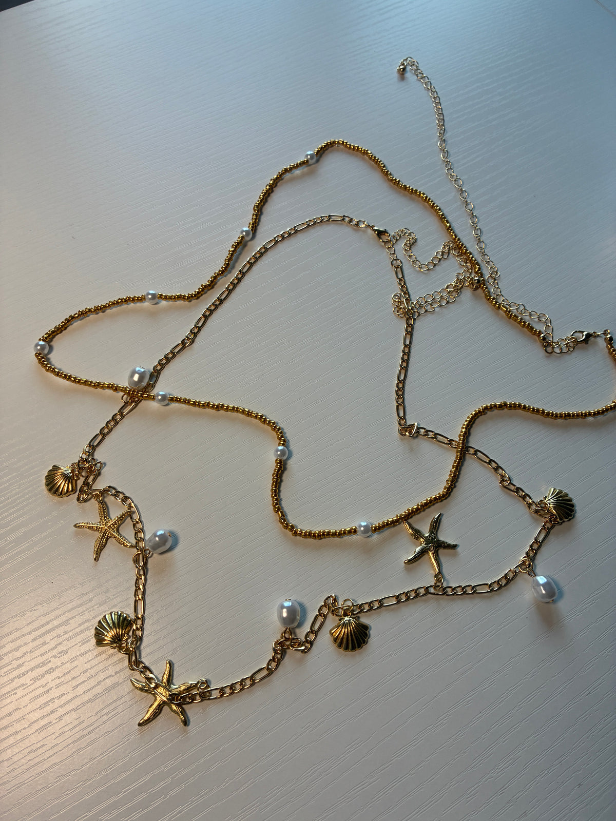 Chaîne de taille dorée coquillages, étoiles de mer et perles